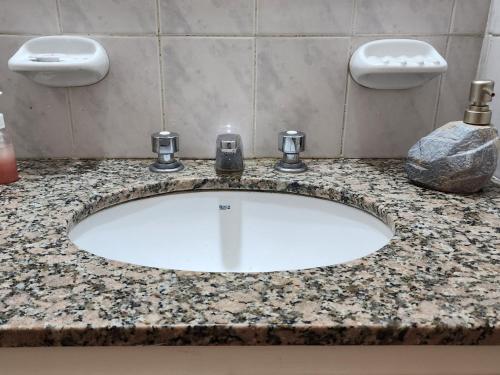 a bathroom sink with two faucets on a counter at Dptos en Consorcio Florentino in San Juan