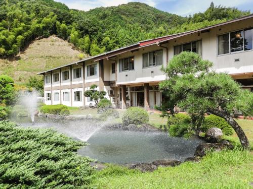a building with a pond in front of a building at Ichinomata Onsen Grand Hotel in Shimonoseki