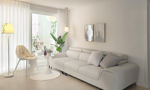 a white living room with a couch and a table at Gyeongju Florian Stay Stay Close Explore More in Gyeongju