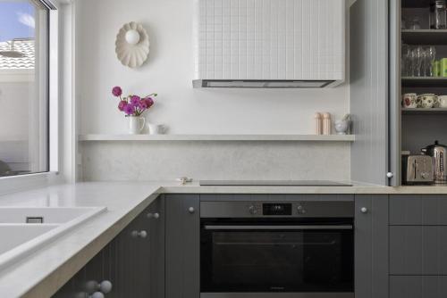 a kitchen with a black oven and a sink at Harlech House Rye in Rye