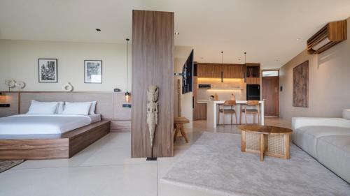 a bedroom with a bed and a living room at Sore Escape Tumbak Bayuh by Betterplace in Tumbak Bayuh
