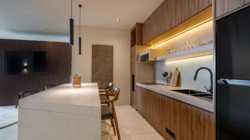 a kitchen with a white counter and a kitchen island at Sore Escape Tumbak Bayuh by Betterplace in Tumbak Bayuh