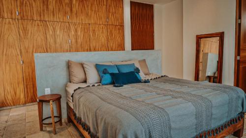a bedroom with a large bed with blue pillows at Casa del Loro 3 BR Luxury Villa with Private Pool in Tulum