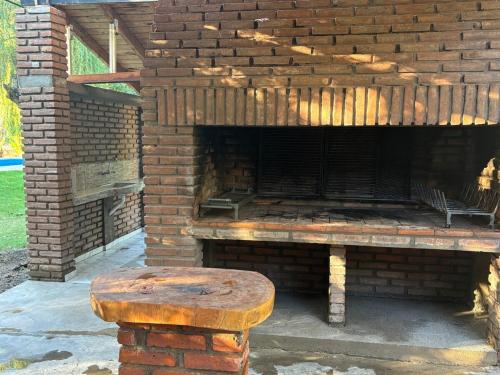 a brick fireplace with a wooden bench in front of it at Casa quinta soñada in Pocito