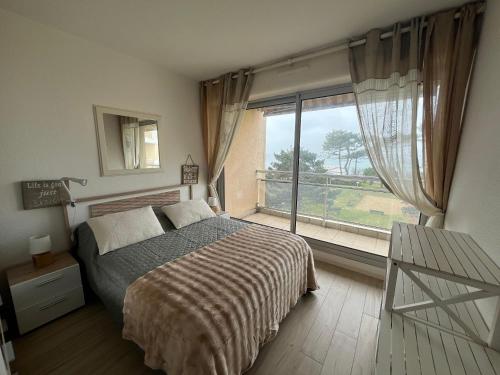 sypialnia z łóżkiem i dużym oknem w obiekcie Appartement T2 bis avec balcon, parking et WIFI à Arcachon - FR-1-374-199 w Arcachon