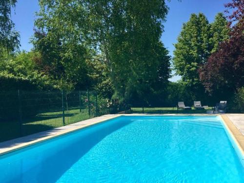 une piscine avec de l'eau bleue dans une cour dans l'établissement Gîte historique avec piscine privée, proche de Chinon - FR-1-381-530, à Ligré