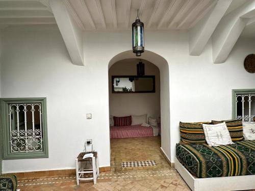 a living room with a couch and a mirror at Dar la famille Marrakech in Marrakech