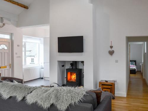a living room with a couch and a fireplace at Katellen Cottage in Threlkeld