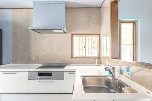 a kitchen with white cabinets and a sink at 那須キャッスルロッジ,4000平米の広大な森を独り占め in Nasu