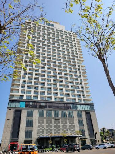 a tall building with cars parked in front of it at Apec Mandala Phú Yên - Luxury Codotel in Phước Hậu