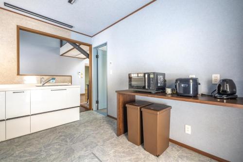a kitchen with a sink and a microwave at 那須キャッスルロッジ,4000平米の広大な森を独り占め in Nasu