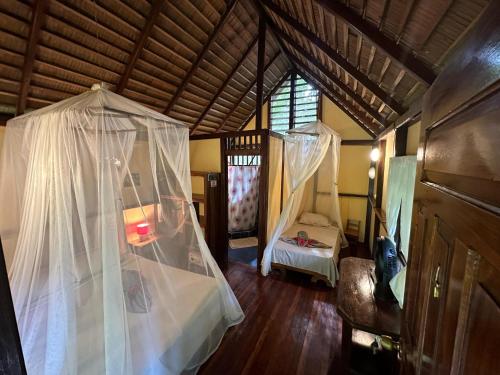 a bedroom with a canopy bed in a room at Alby Lodge Cahuita in Cahuita