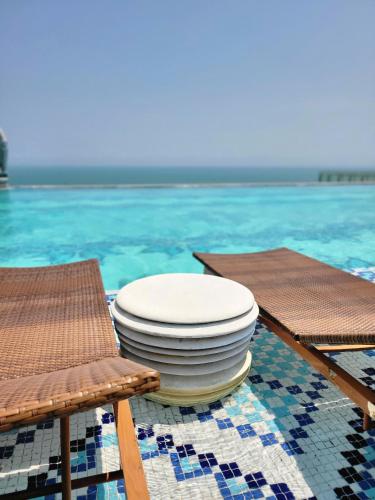 a stack of plates on a table next to two chairs at Apec Mandala Phú Yên - Luxury Codotel in Phước Hậu