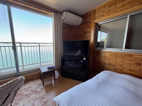 a bedroom with a bed and a flat screen tv at uliuli in Kuka