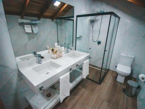 a bathroom with a sink and a shower and a toilet at Paraíso do Salto in Lages