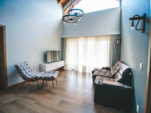 a living room with a couch and two chairs at Paraíso do Salto in Lages