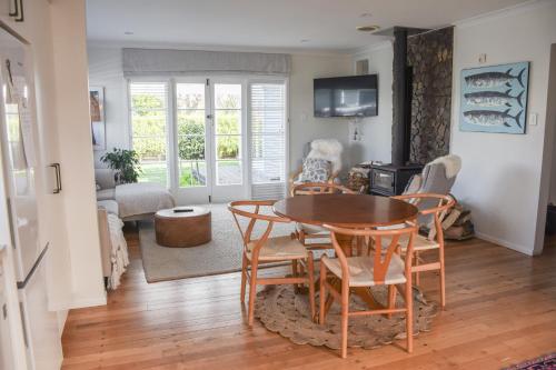 a living room with a table and chairs at Beautiful home with short stroll to Havelock Village in Havelock North