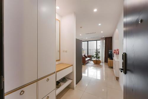 a kitchen with white cabinets and a living room at HN ETH Vinhomes D'capitale Resident - Tran Duy Hung St in Hanoi