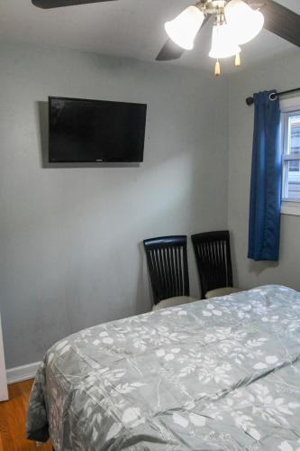 a bedroom with a bed and two chairs and a flat screen tv at Home Away From Home in Skokie