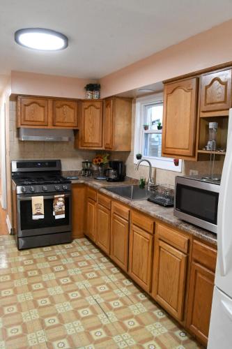 a kitchen with wooden cabinets and a stove top oven at Home Away From Home in Skokie