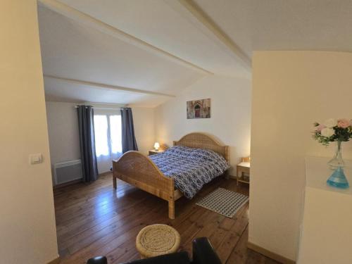 a bedroom with a bed and a vase of flowers at Gîte Authentique avec Piscine, Cheminée et Étang Privé à Naussannes - Proche Bergerac - FR-1-616-205 in Naussannes