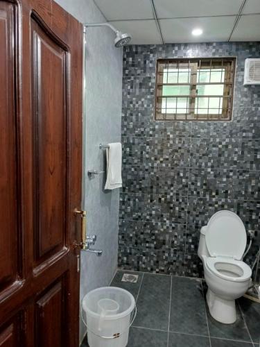 a bathroom with a toilet and a window at Osama's Room for Rent in Murree