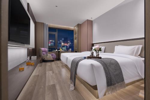 a hotel room with a large bed and a tv at Wenzhou wumajie all-weather hotel shamao river branch - located in the city center pedestrian street with breakfast coffee afternoon tea free laundry drying service free gym free daily necessities free wifi tourist attractions hotel recommendation in Wenzhou