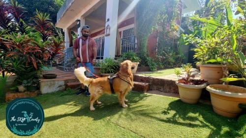 a man and his dog in front of a house at Parijat-Breathtaking Sky and Hilltop view in Dapoli