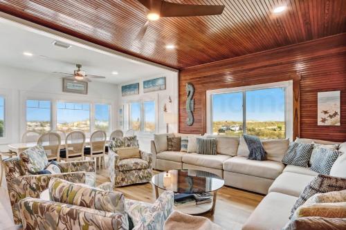 a living room with couches and tables and windows at DogFriendly Beachfront Condo in Fernandina Beach