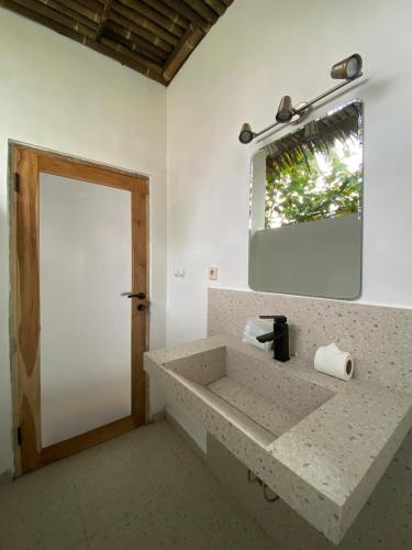 a bathroom with a sink and a mirror at Madasari Village in Madasari