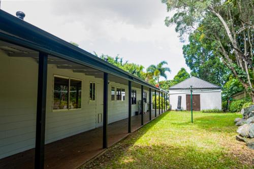 a building with a row of windows next to a yard at Station Tallara Retreat in Bahrs Scrub