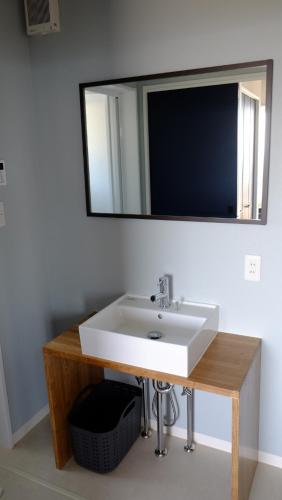 a bathroom with a white sink and a mirror at 新築オーシャンビュー離れ FLAG Awaji HANARE in Awaji