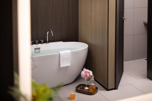 a white bath tub in a bathroom with flowers on the floor at Wenzhou wumajie all-weather hotel shamao river branch - located in the city center pedestrian street with breakfast coffee afternoon tea free laundry drying service free gym free daily necessities free wifi tourist attractions hotel recommendation in Wenzhou