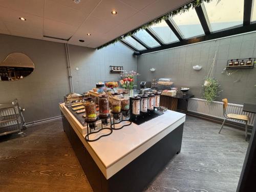 a counter with food on it in a room with windows at Hotel de Duif Lisse - Keukenhof in Lisse