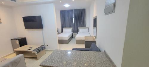 a living room with a room with two beds and a couch at مراسيم للشقق الفندقية in Amman