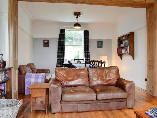 a living room with a leather couch and a table at Kingswood in Whitehaven