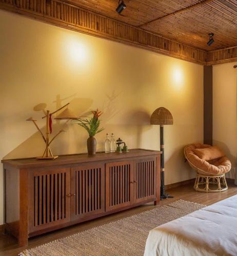 a bedroom with a bed and a table with a lamp at Hồ Đá Cổ Thiên Long Resort Hòa Bình in Hòa Bình