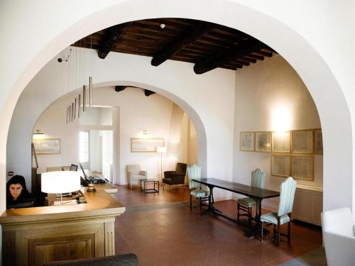 a woman sitting at a table in a dining room at Residence Villa Il Palagio, Rignano sull" Arno in Rignano sullʼArno