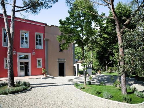 a red building with trees in front of it at Residence Villa Il Palagio, Rignano sull" Arno in Rignano sullʼArno
