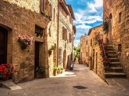 an alley in an old stone building with flowers at Residence Villa Il Palagio, Rignano sull" Arno in Rignano sullʼArno