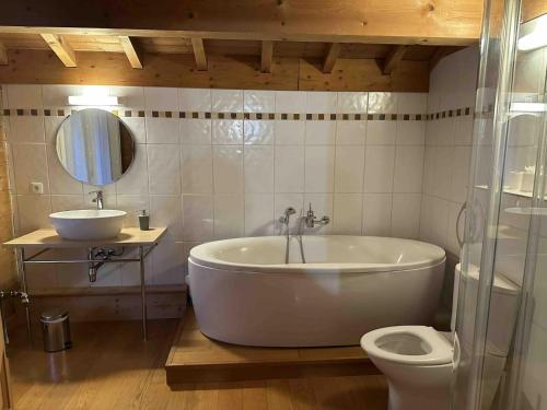 une salle de bain avec une baignoire, un lavabo et des toilettes dans l'établissement Chalet spacieux 15 pers, proche remontées, balcon, terrasse - FR-1-676-208, à Châtel