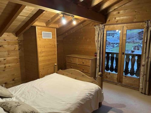 une chambre avec un lit dans une pièce aux murs en bois dans l'établissement Chalet spacieux 15 pers, proche remontées, balcon, terrasse - FR-1-676-208, à Châtel