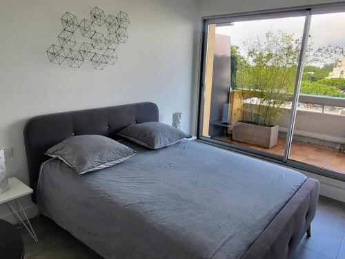 un lit dans une chambre avec une grande fenêtre dans l'établissement Appartement avec Terrasse Lumineuse à La Grande-Motte - FR-1-716-82, à La Grande Motte