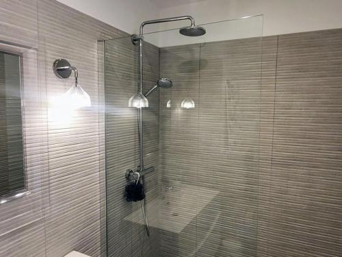 une douche avec deux lumières et une porte en verre dans l'établissement Appartement avec Terrasse Lumineuse à La Grande-Motte - FR-1-716-82, à La Grande Motte