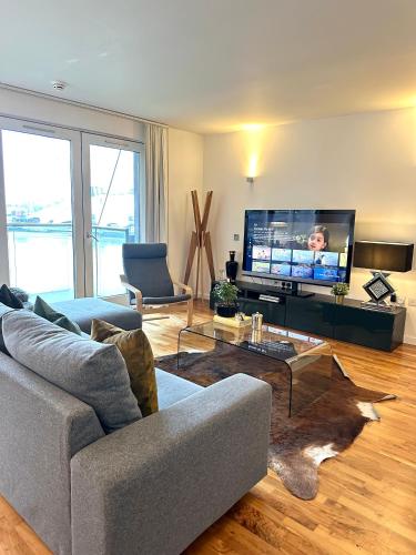 a living room with a couch and a flat screen tv at Luxury apartment in Canary Wharf in London