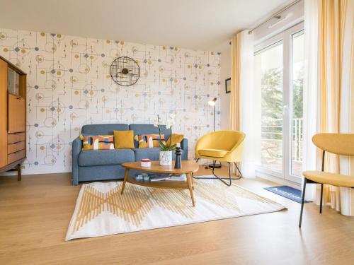 un salon avec un canapé bleu et une table dans l'établissement Appartement rénové, lumineux proche plage avec parking - FR-1-306-1299, à Saint-Brévin-les-Pins