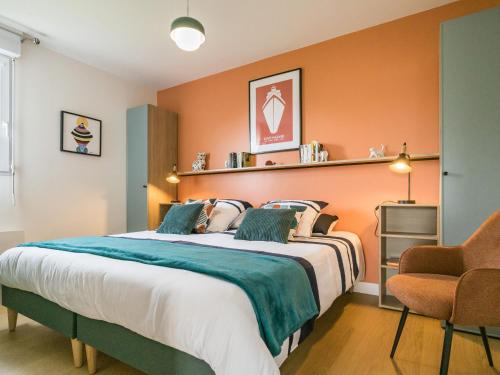 une chambre avec un grand lit avec un mur orange dans l'établissement Appartement rénové, lumineux proche plage avec parking - FR-1-306-1299, à Saint-Brévin-les-Pins
