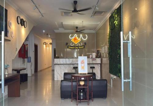 a lobby of a restaurant with a couch and a counter at Grand City Hotel Kuantan in Kuantan