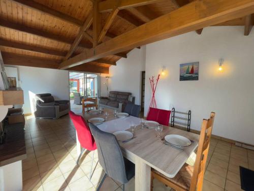 une salle à manger avec une table et des chaises rouges dans l'établissement Maison avec véranda, jardin clos, 2 chambres - Proche centre et océan - FR-1-224C-338, à Saint-Jean-de-Monts
