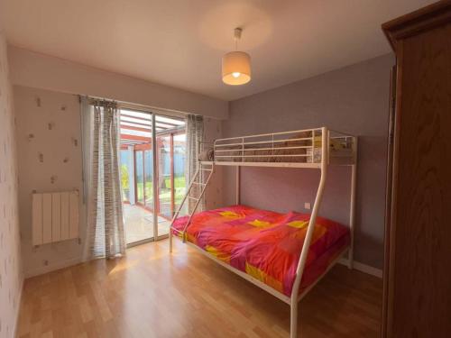 une chambre avec un lit superposé et une grande fenêtre dans l'établissement Maison avec véranda, jardin clos, 2 chambres - Proche centre et océan - FR-1-224C-338, à Saint-Jean-de-Monts